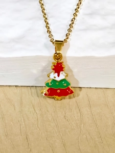 Macro shot of a gold necklace featuring a festive red and green enamel Christmas tree pendant