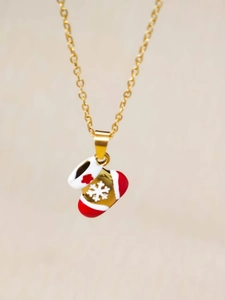 Close-up of a festive Christmas stocking pendant with gold snowflake and red flower details