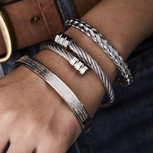 Detailed macro view of three-piece silver men's stainless steel woven bracelet set
