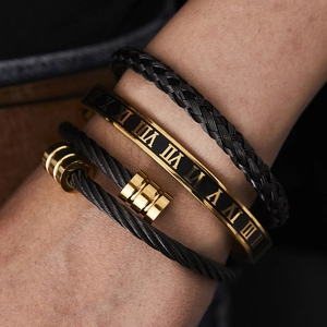 Close-up of black braided rope and gold Roman numeral bracelets for men in a set