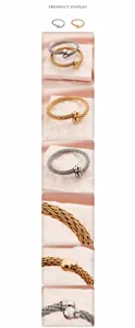 Dettaglio di bracciali a cavo intrecciato oro e argento con perle sferiche su raso