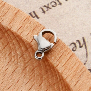 Polished silver stainless steel lobster clasp on a wooden block for DIY jewelry