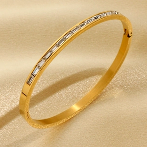 18K vergoldetes Armband mit einer Reihe von Zirkonia im Baguetteschliff auf Seidenhintergrund