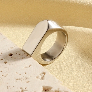 Bague géométrique minimaliste en acier inoxydable poli sur pierre de travertin chic