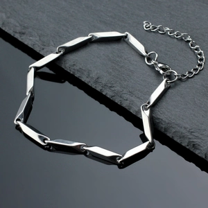Polished stainless steel prism link necklace with lobster clasp on rock background