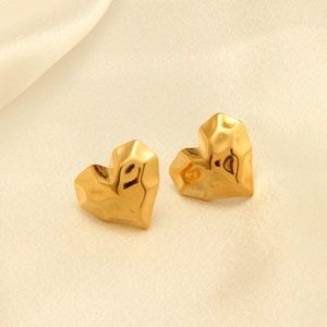 Detalle de pendientes de corazón en oro de 18 quilates con acabado geométrico