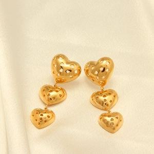 Vista detallada de pendientes de tres corazones calados bañados en oro de 18 quilates