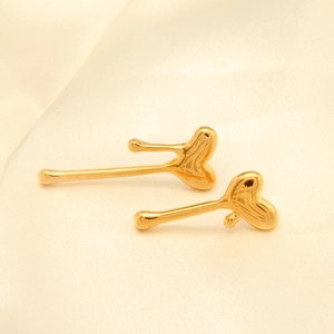 Detalle de los pendientes de corazón en oro de 18k con acabado de metal líquido pulido