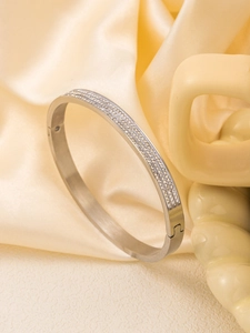 Detail view of silver stainless steel bangle with three rows of pavé set white zirconias
