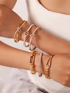 Detailed view of a six-piece gold-toned bracelet set with zircons and Roman numerals