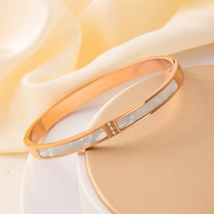 Bracelet élégant en acier rose doré avec incrustation de nacre blanche et trois zircons