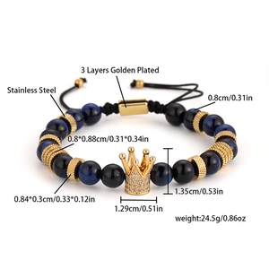 Detalle de pulsera de cuentas de ojo de tigre azul con amuleto de corona dorada