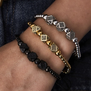 Close-up of men's beaded bracelets featuring micro-pave zircon cubes in gold and black