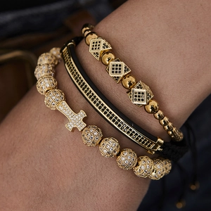 Detail of hip hop set with gold cross charm, micro-pave stones and black silicone band