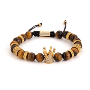 Detalle de pulsera corona de ojo de tigre con colgante dorado y circonitas cúbicas
