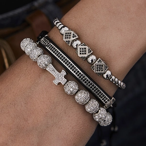 Macro detail of men's hip hop bracelet set featuring iced out cross and cuboid zircon beads