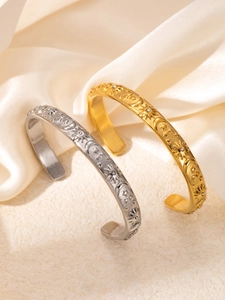 Detalle de patrones de sol luna y estrellas en relieve en pulseras bañadas en oro y plata