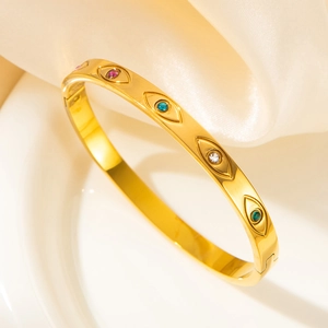 Gold Evil Eye stainless steel bangle with colorful gemstones on elegant silk display