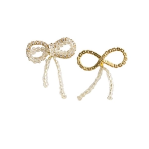Detailed view of crystal beaded bow earrings with sparkling rhinestone tassels in gold