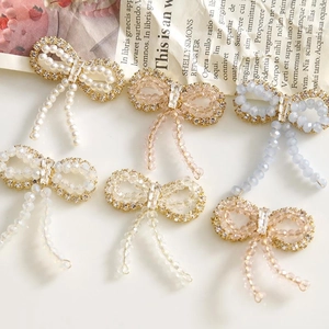 Close-up of elegant bow-shaped beaded earrings with colorful crystals and pearls