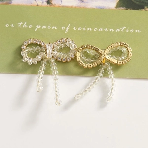 Detailed view of elegant bow jewelry with crystal bead tassels and sparkling rhinestones