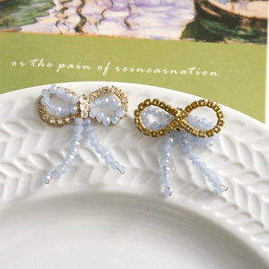 Detail of light blue beaded bow accessory with rhinestones and elegant tassel fringe