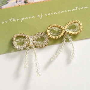 Elegant crystal bow jewelry component with beaded tassels on art display card