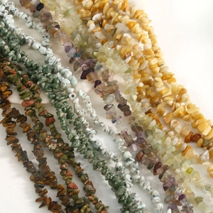 Detailed view of various natural stone chip beads including tiger eye and amethyst