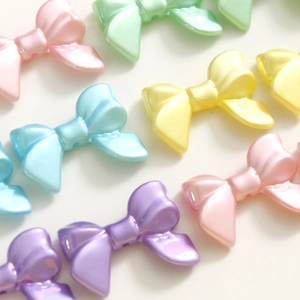 Détail macro de perles nœuds en acrylique couleurs macaron avec fini perlé pour bijoux DIY