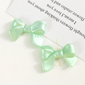 Vue macro de nœuds en acrylique vert menthe nacré pour accessoires de coiffure DIY