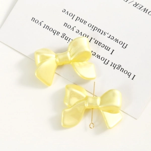 Détails macro de nœuds en acrylique nacré jaune macaron pour la création de bijoux DIY