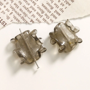Primer plano de cuentas de vidrio gris translúcido en forma de engranaje para joyería DIY