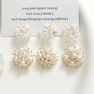 Gros plan sur des grappes de fleurs de perles et breloques irisées pour bijoux DIY