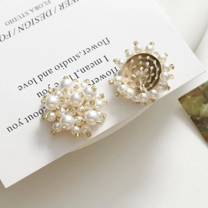 Détail de boucles d'oreilles trèfle en perles tissées main avec base en métal doré