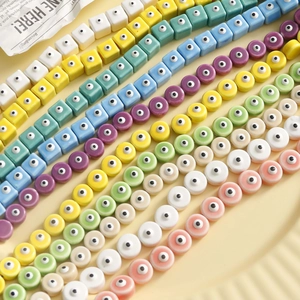 Dettaglio macro di perle geometriche colorate con motivi a occhio per creazione di gioielli