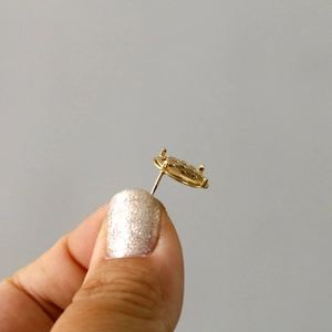 Macro detail of gold-plated copper prong earring bases for DIY jewelry making