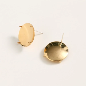 Macro detail of gold plated copper earring base with four-prong setting and smooth finish