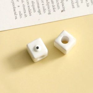 Dettaglio macro di perle cubiche bianche con motivo a occhio per gioielli fai-da-te