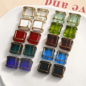 Macro detail of square glass beads with gold hand-painted edges for DIY jewelry making