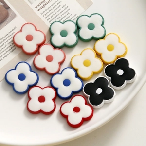 Detailed macro view of colorful four-petal acrylic flower beads for DIY jewelry making