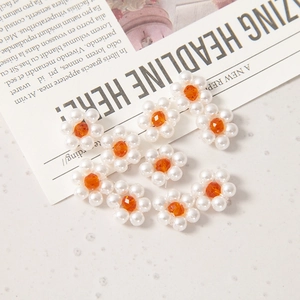 Vue détaillée de perles fleurs 12mm faites main avec perles blanches et cristaux orange