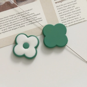 Macro shot of green and white resin floral acrylic charms for DIY jewelry making