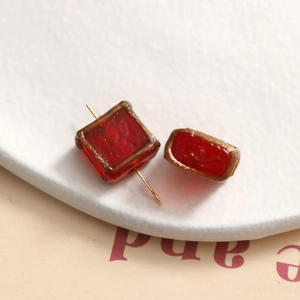 Macro shot of gold-edged red glass beads for DIY jewelry and handmade accessories