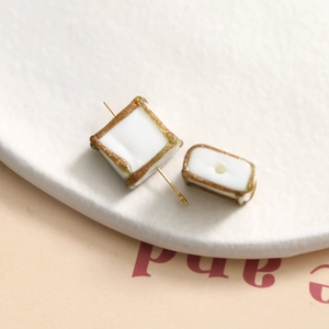 Macro shot of square glazed glass beads with gold glitter trim for DIY jewelry making