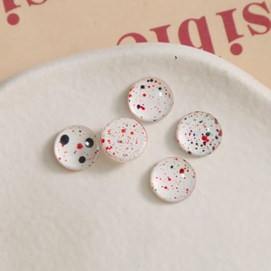Detail showing five 10mm glass cabochons with artistic red and black ink splatter patterns