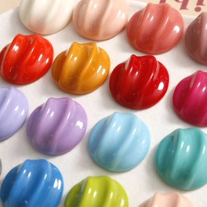 Macro view of colorful ribbed resin charms with a vibrant pleated semi-circle design