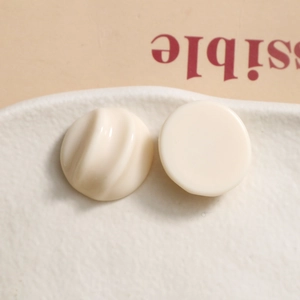 Detailed macro view of chic cream resin semi-circle charms with spiral textures