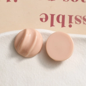 Detail of nude pink resin charms with spiral texture and smooth finish for DIY jewelry crafts