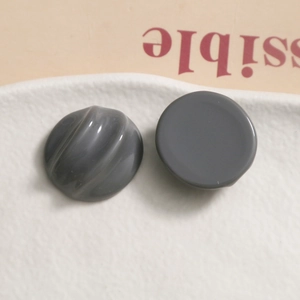 Detail of dark gray resin semi-circle resin charms with smooth and spiral textured surfaces