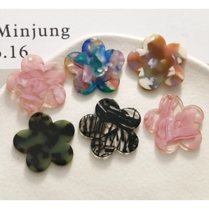 Macro detail of assorted acetate flower charms with various textures for DIY jewelry making